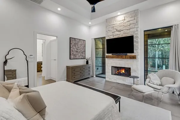 a spacious bedroom with a bed and a flat screen tv