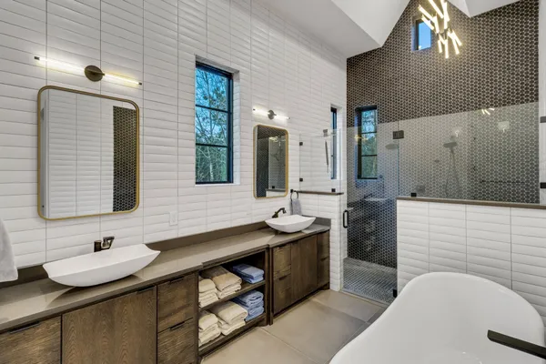 a bathroom with double sink and two mirror