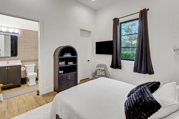 a bedroom with a bed and a flat tv screen on the dresser
