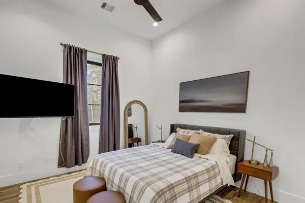 a bedroom with a bed and a flat screen tv