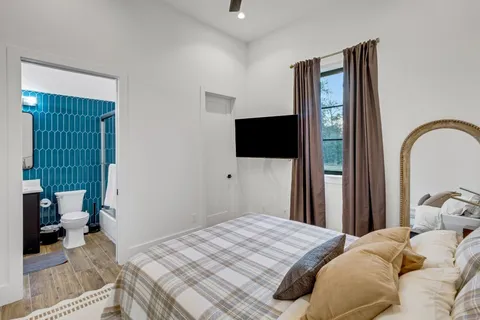 a bedroom with a bed and a flat tv screen