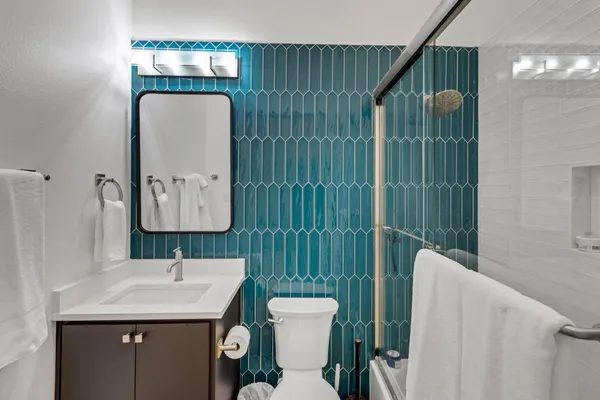 a bathroom with a toilet sink and mirror
