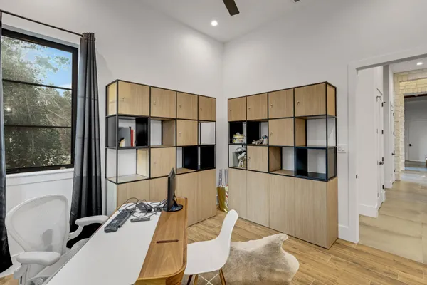a kitchen with stainless steel appliances kitchen island granite countertop a refrigerator a stove and white cabinets with wooden floor