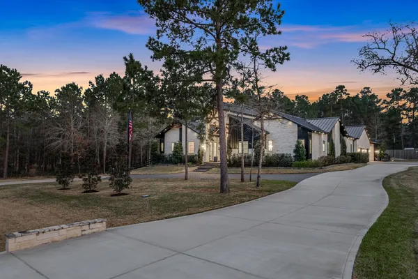 a front view of a house with a yard and tree s