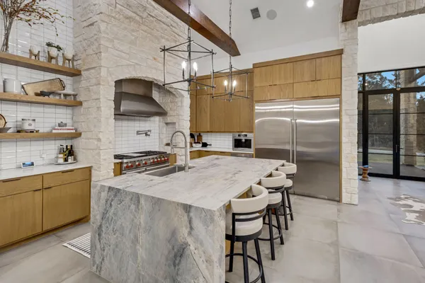 a kitchen with stainless steel appliances granite countertop a sink a stove and a refrigerator