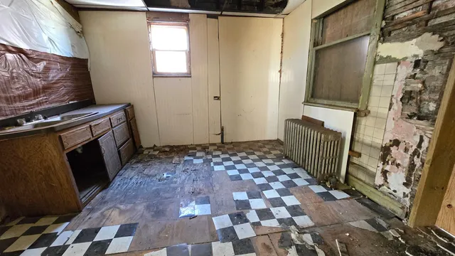 a view of a house with wooden fence next to a yard