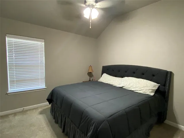 a bed sitting in a bedroom next to a window