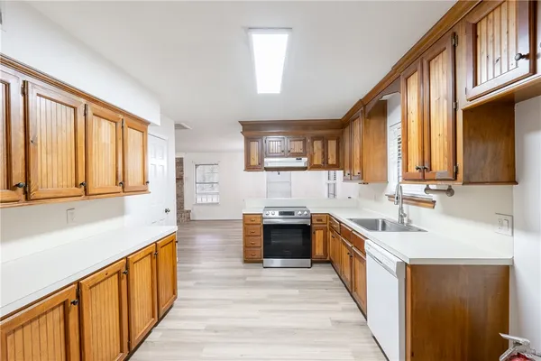 a large kitchen with stainless steel appliances kitchen island granite countertop a sink dishwasher stove and cabinets with wooden floor