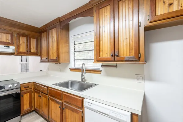 a kitchen with stainless steel appliances granite countertop a sink and a wooden cabinets