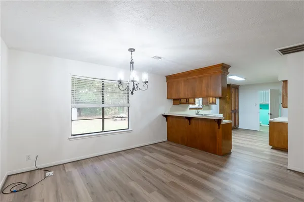 a view of kitchen with granite countertop window and wooden floor