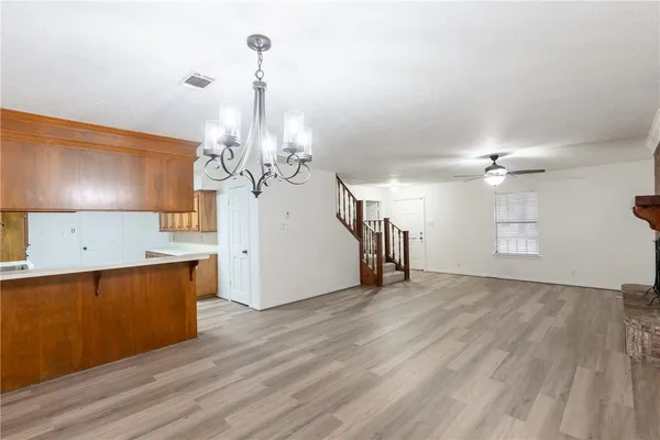 a view of a kitchen with wooden floor and a chandelier