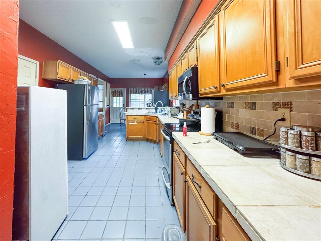 5510 Rolling Green Road Arlington, TX 76017 - Photo 9 of 19 a kitchen with a sink a counter top space and stainless steel appliances