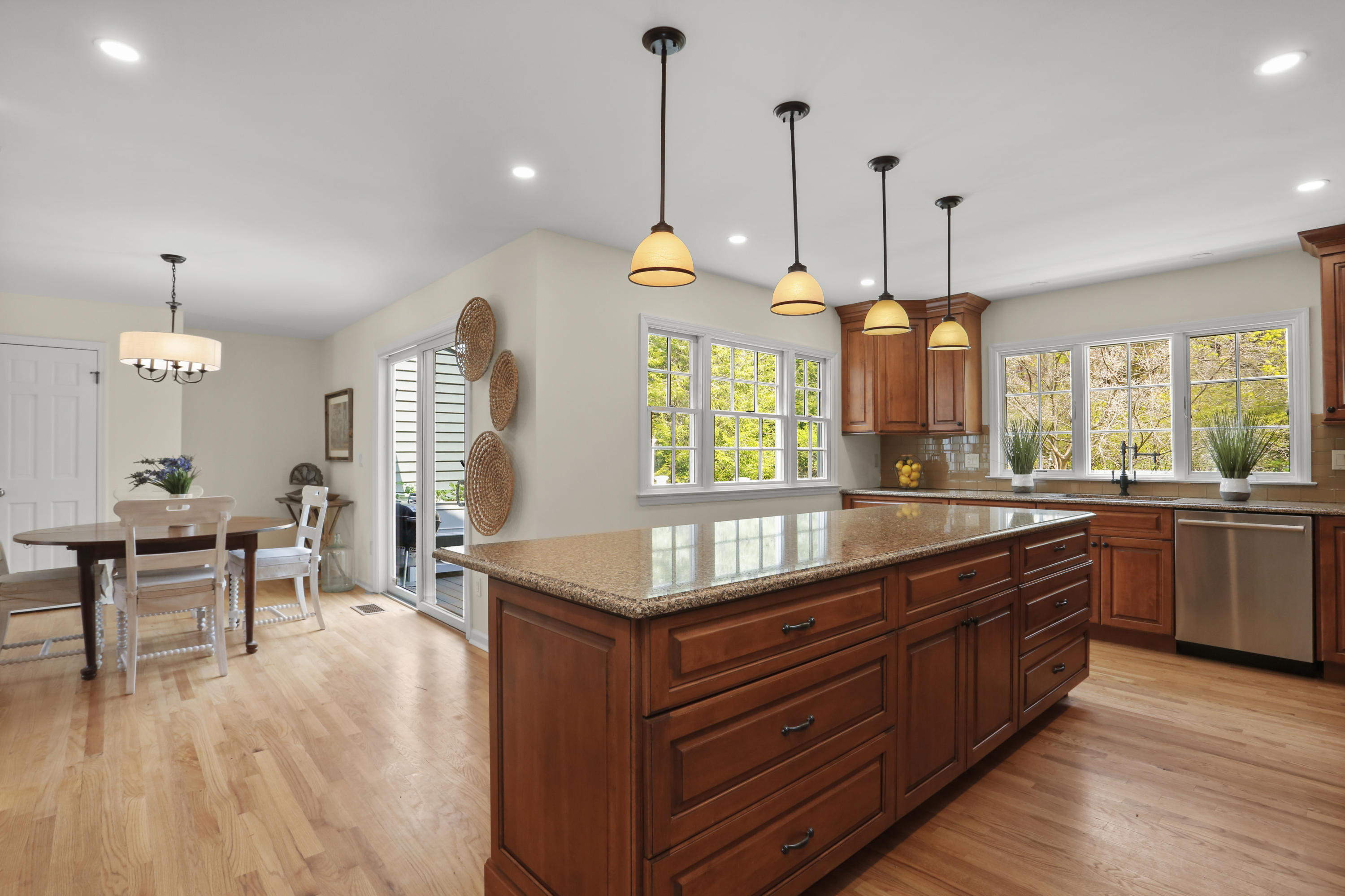 8 Ridge Farms Road Norwalk, CT 06850 - Photo 10 of 31 a kitchen with granite countertop a stove a sink a dining table and chairs with wooden floor