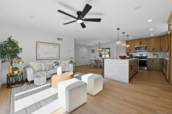 a living room with furniture kitchen and a wooden floor