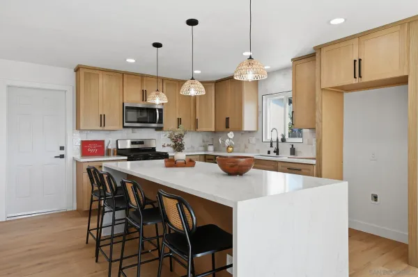 a kitchen with kitchen island a sink counter and chairs