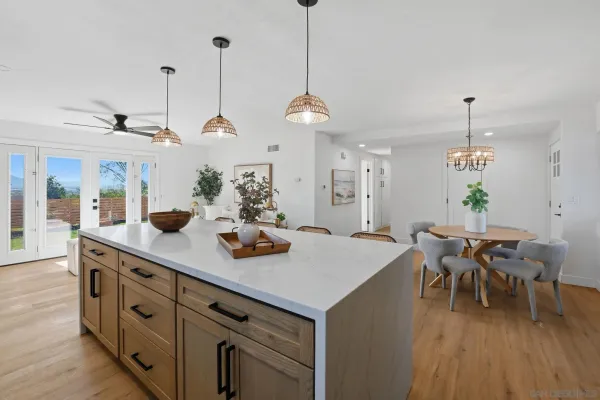 a view of a dining room and livingroom with furniture wooden floor a chandelier