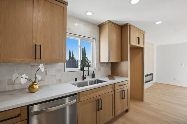a kitchen with stainless steel appliances granite countertop a sink and a refrigerator