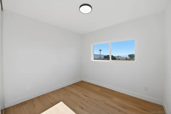 a view of a room with wooden floor and fan