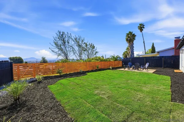 a view of a house with backyard and sitting area