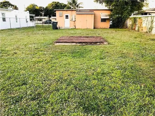 a view of a backyard with wooden fence