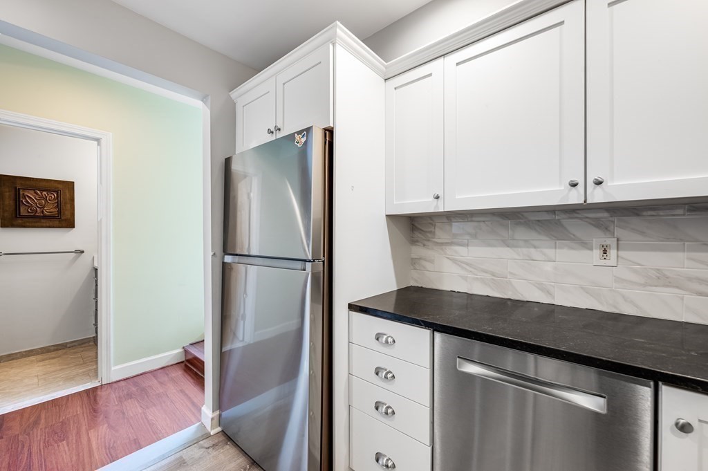 116 Milton Street, Unit 231 Dedham, MA 02026 - Photo 3 of 27 a kitchen with a refrigerator sink and cabinets