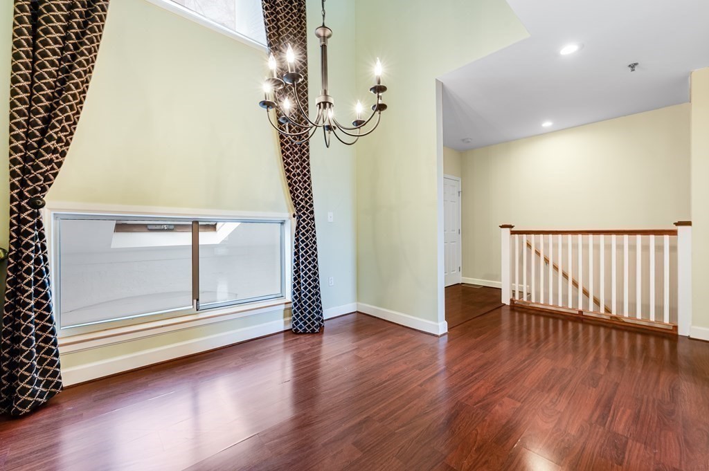 116 Milton Street, Unit 231 Dedham, MA 02026 - Photo 6 of 27 a view of a livingroom with wooden floor and stairs