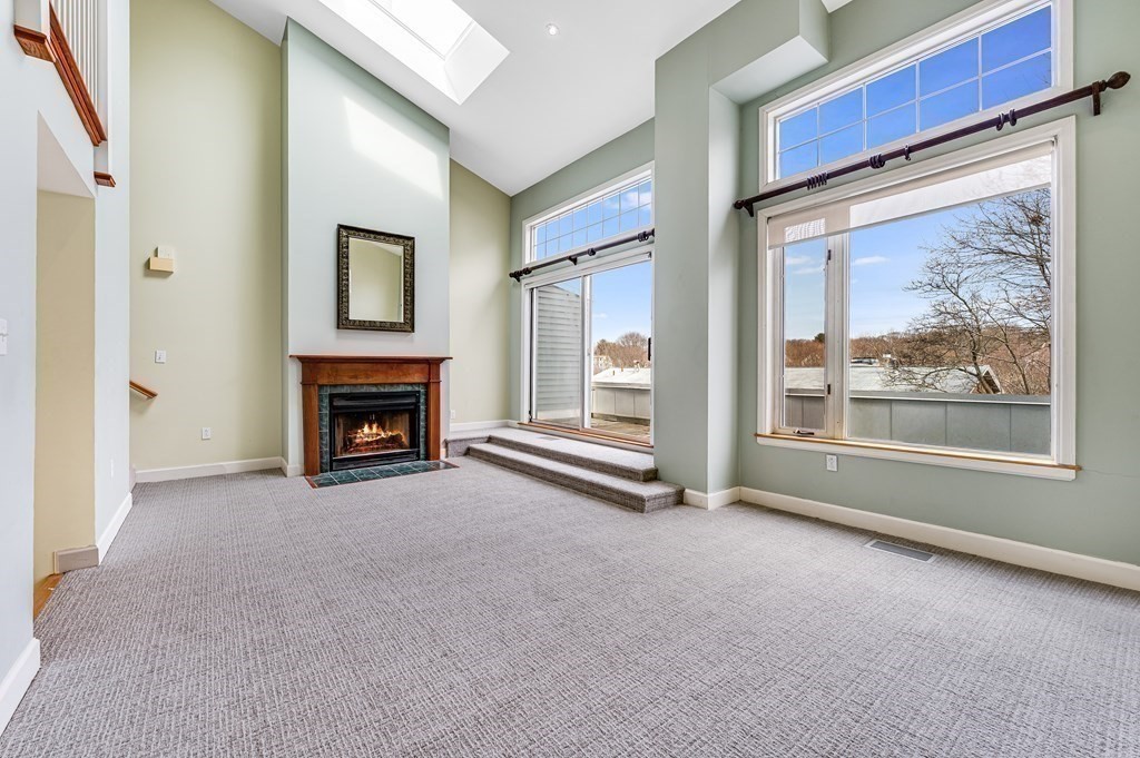 116 Milton Street, Unit 231 Dedham, MA 02026 - Photo 8 of 27 a view of an empty room with a fireplace and a window