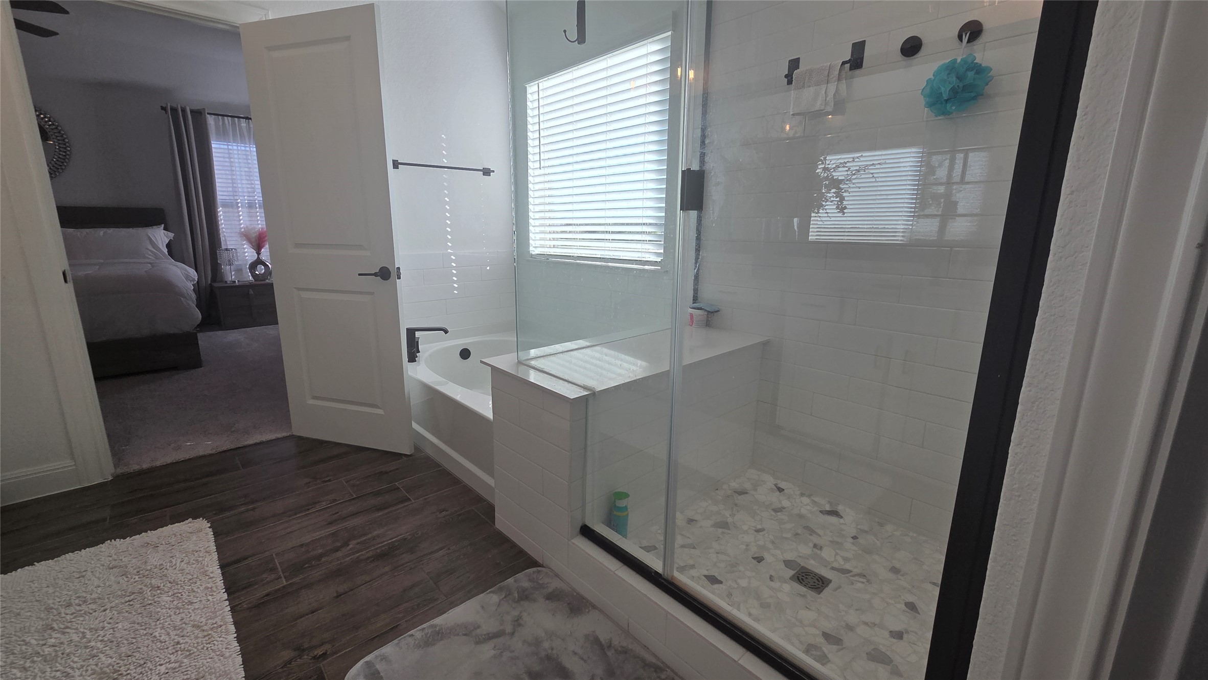 125 Raleigh Drive Georgetown, TX 78633 - Photo 19 of 30 Bathroom featuring a garden tub, ensuite bathroom, a stall shower, and dark wood-style flooring