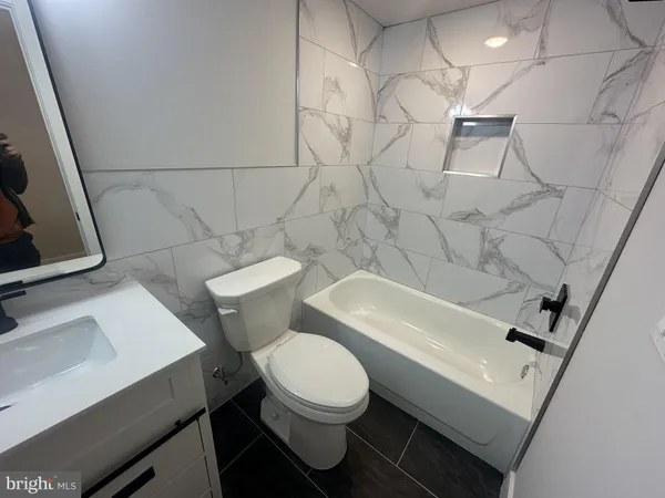 a white toilet sitting next to a bath tub