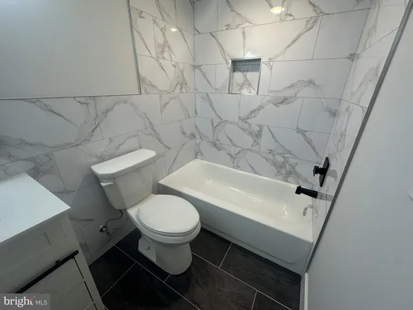 a white toilet sitting next to a white tub