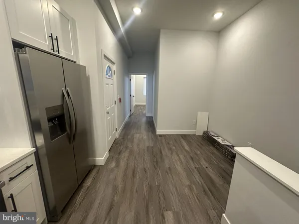 a view of hallway with wooden floor and electronic appliances
