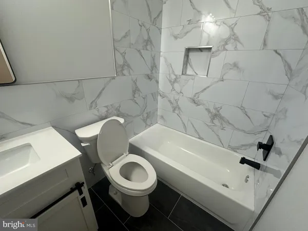 a bathroom with a sink mirror toilet and bathtub