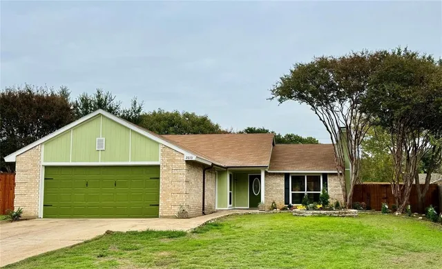 a front view of a house with a yard and trees
