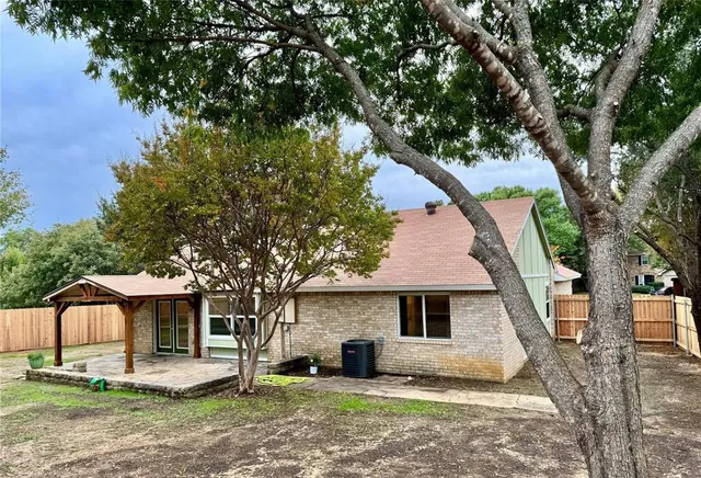 a backyard of a house with barbeque oven table and chairs