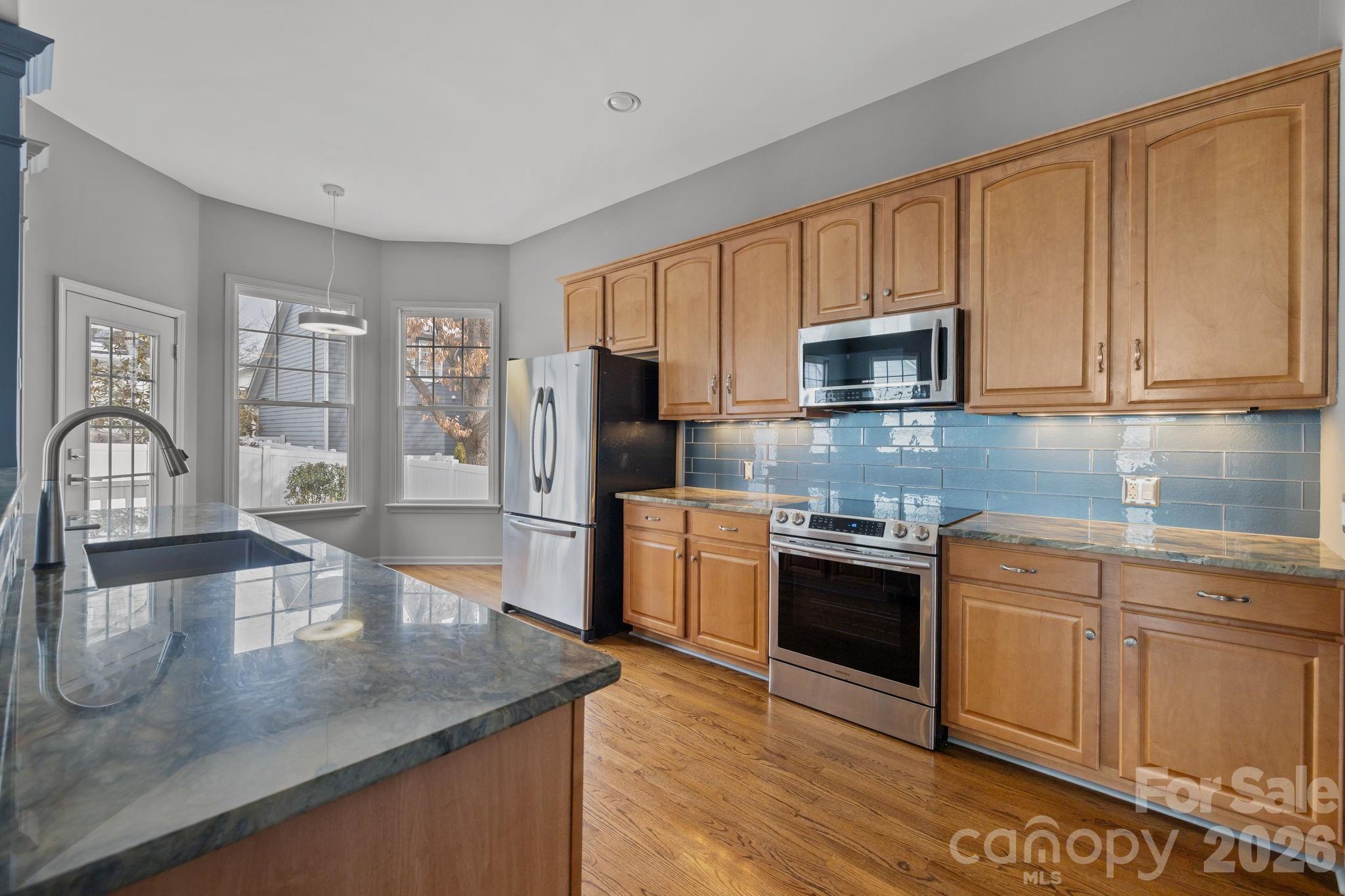 173 Blandina Court, Unit 426 Fort Mill, SC 29708 - Photo 7 of 32 a kitchen with stainless steel appliances granite countertop a stove a sink and a microwave