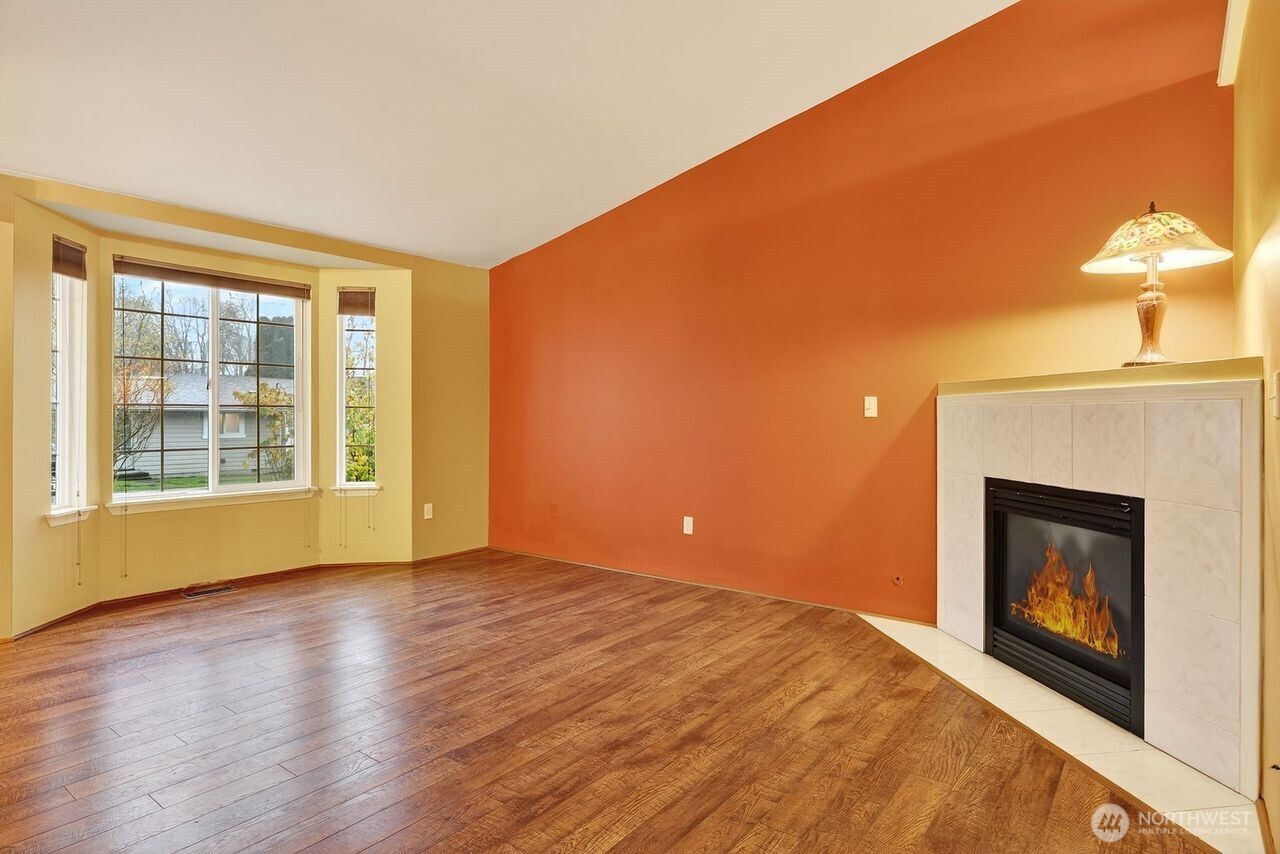708 Marquette Avenue Snohomish, WA 98290 - Photo 6 of 33 a view of an empty room with wooden floor fireplace and a window
