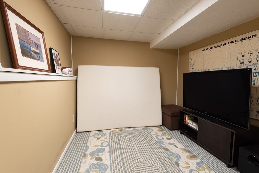 13 Mountain Gate Road, Unit 13 Ashland, MA 01721 - Photo 15 of 21 a living room with a flat screen tv and a white bed