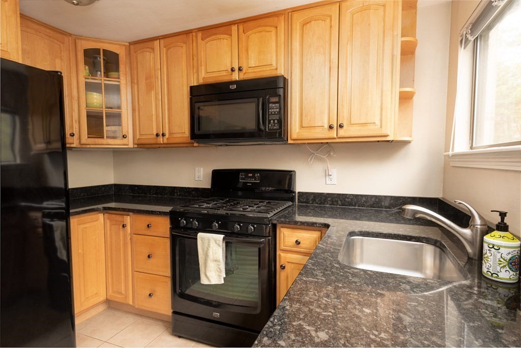 13 Mountain Gate Road, Unit 13 Ashland, MA 01721 - Photo 6 of 21 a kitchen with stainless steel appliances granite countertop a stove a microwave and a sink