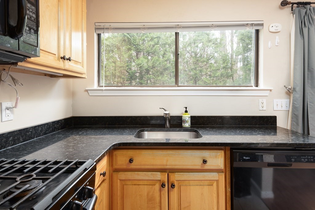 13 Mountain Gate Road, Unit 13 Ashland, MA 01721 - Photo 7 of 21 a kitchen with granite countertop a stove and white cabinets