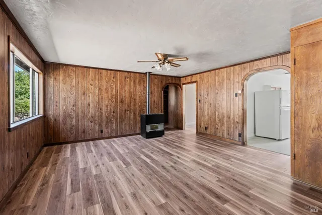 a view of a livingroom with wooden floor and a ceiling fan