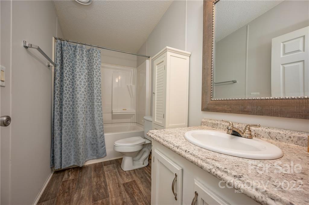 1139 Piney Knob Road Rutherfordton, NC 28139 - Photo 19 of 37 a bathroom with a granite countertop sink toilet and shower curtains
