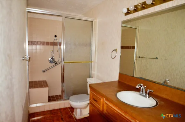 a bathroom with a sink toilet and shower