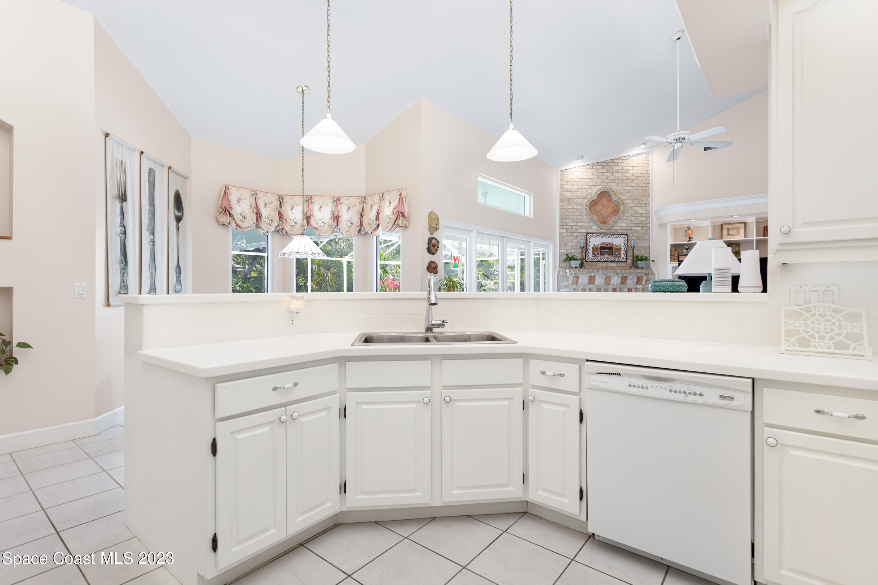442 Sanderling Drive Indialantic, FL 32903 - Photo 16 of 45 a kitchen with white cabinets appliances and a chandelier