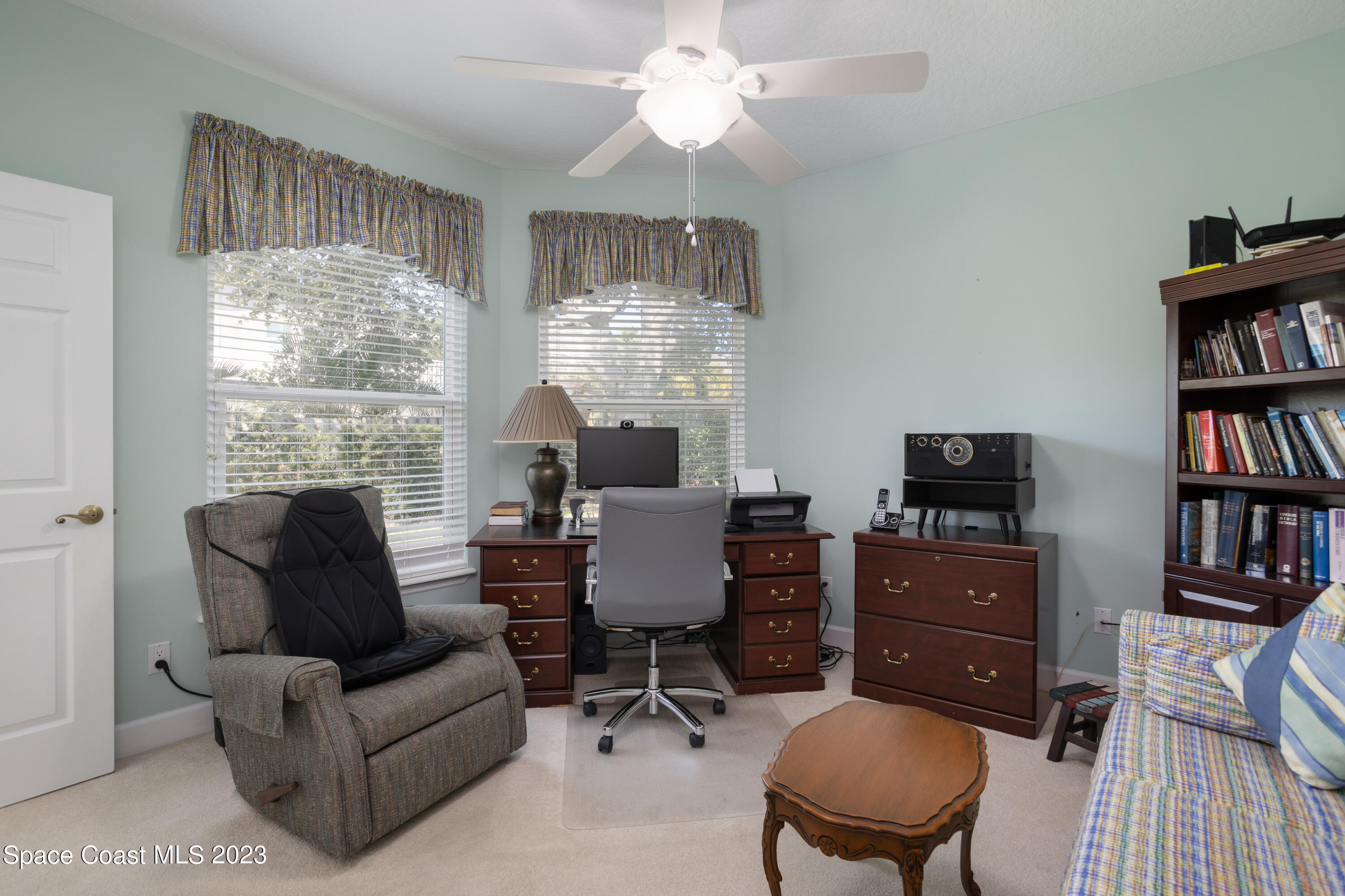 442 Sanderling Drive Indialantic, FL 32903 - Photo 32 of 45 a living room with furniture a bookshelf a window and a flat screen tv