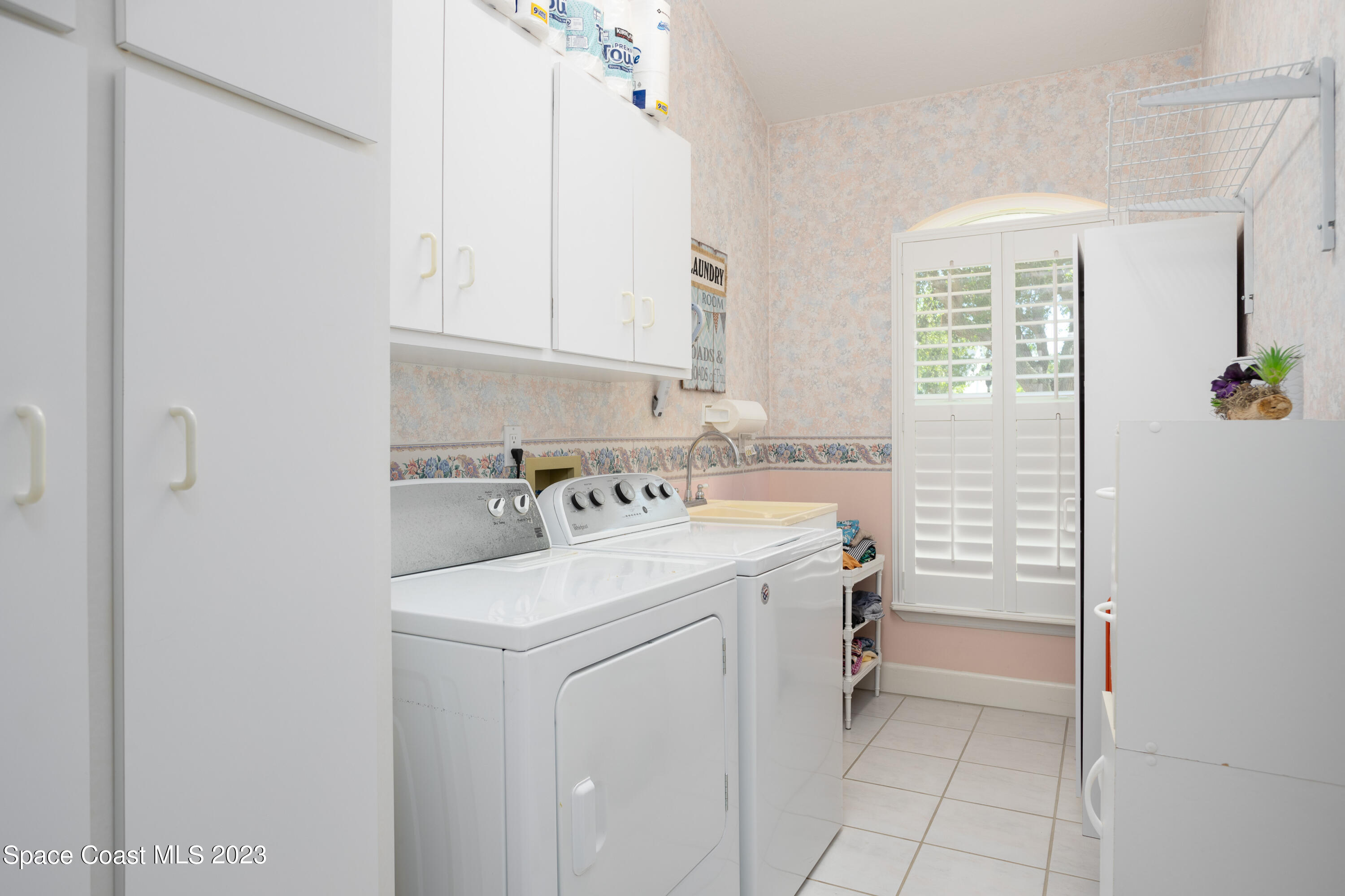 442 Sanderling Drive Indialantic, FL 32903 - Photo 34 of 45 a utility room with cabinets washer and dryer