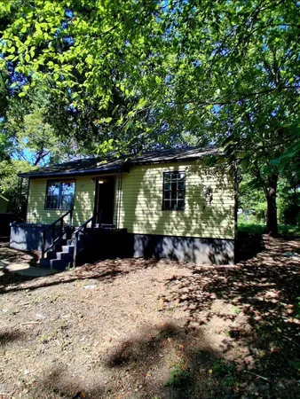 a view of house with yard outdoor seating and covered with green space