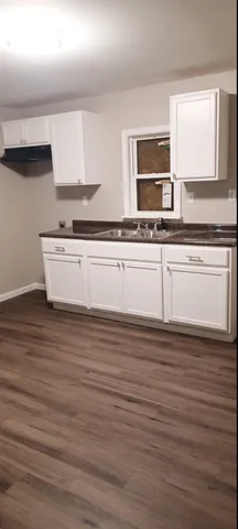 a view of kitchen with stainless steel appliances a sink and wooden floor