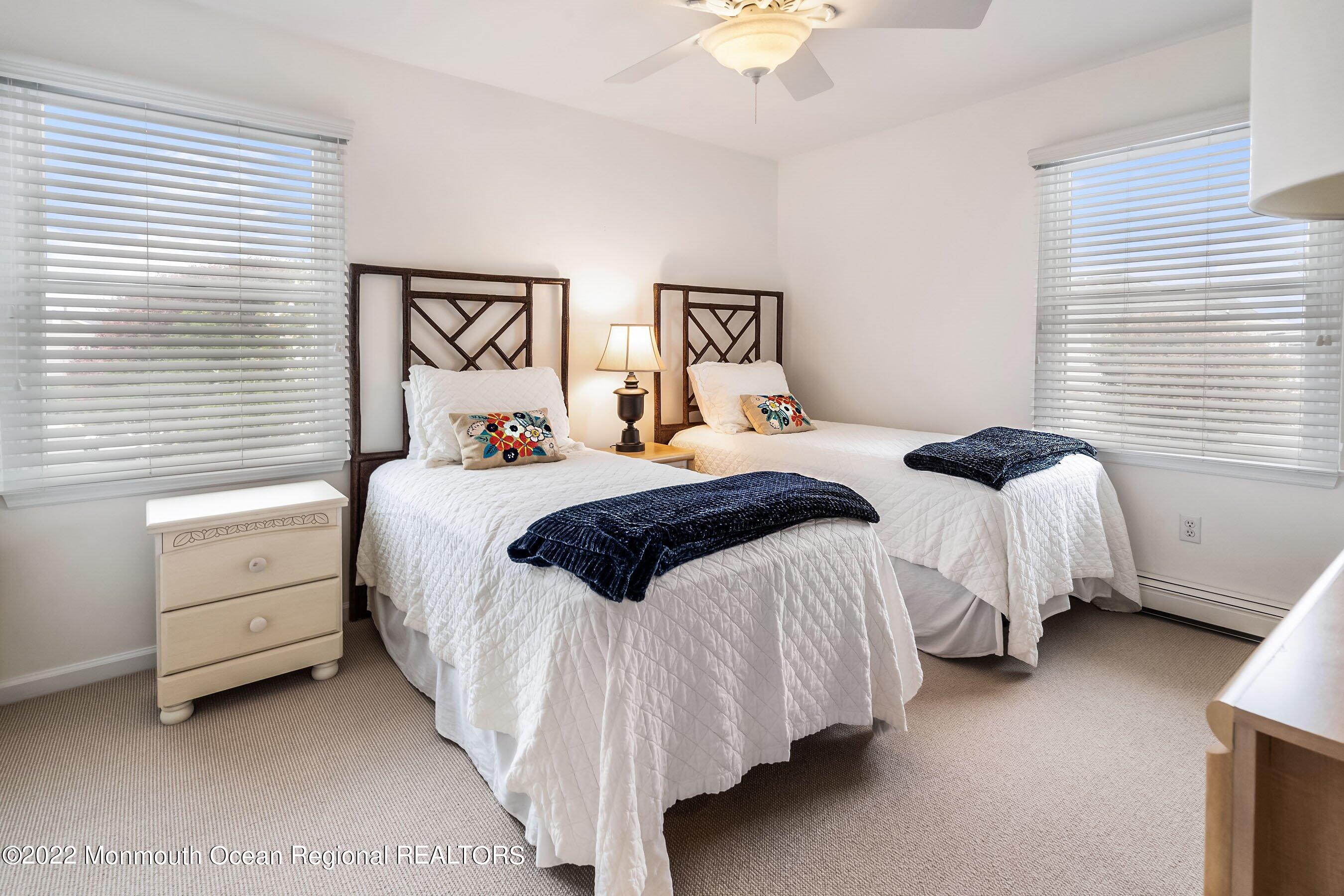 23 Magee Avenue, Unit SUMMER Lavallette, NJ 08735 - Photo 20 of 34 a bedroom with two beds and a chandelier