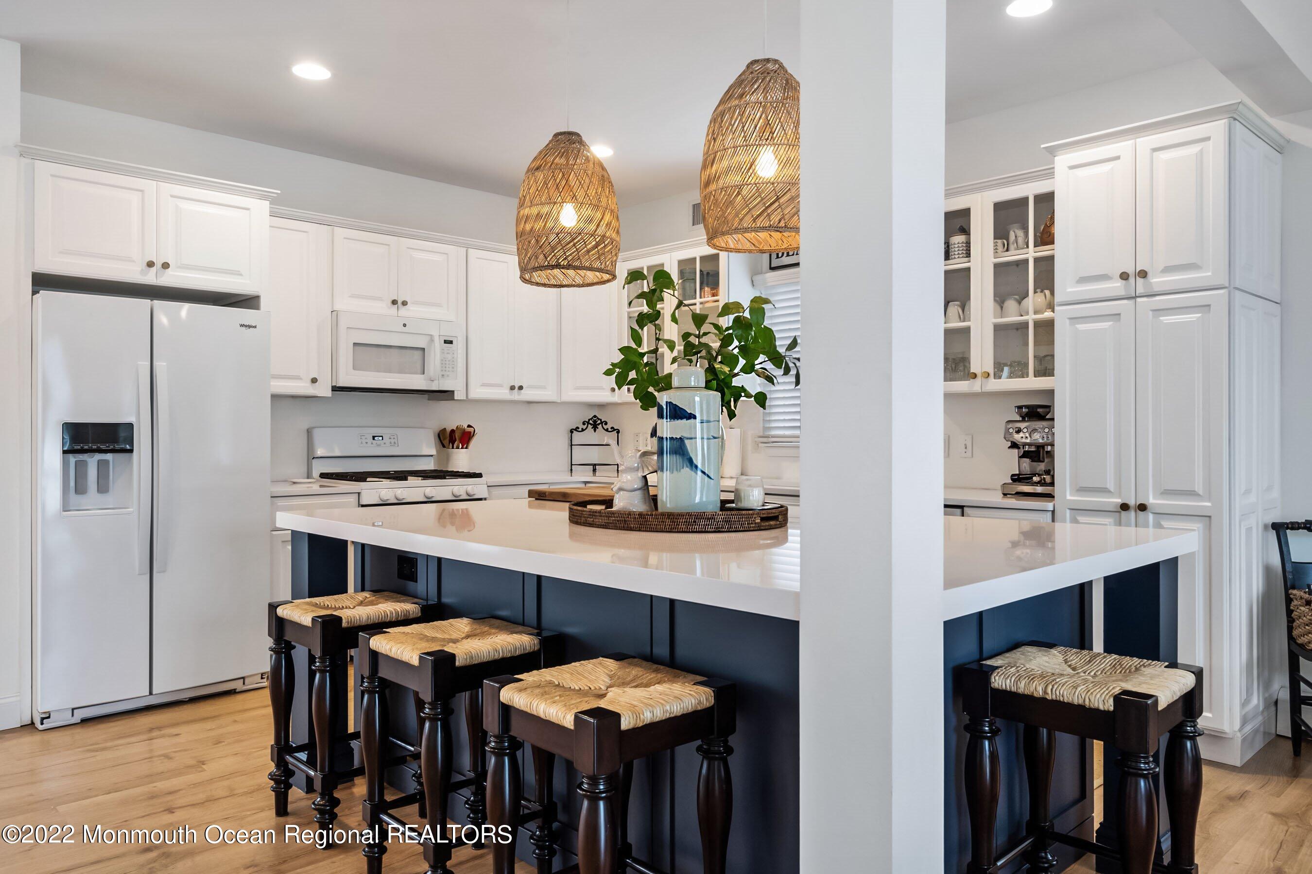 23 Magee Avenue, Unit SUMMER Lavallette, NJ 08735 - Photo 8 of 34 a kitchen with granite countertop a table chairs stove and cabinets