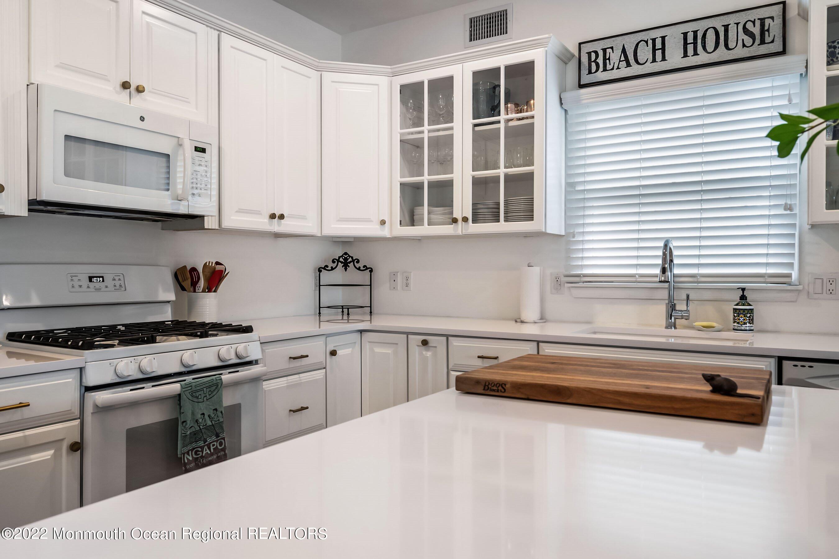 23 Magee Avenue, Unit SUMMER Lavallette, NJ 08735 - Photo 9 of 34 a kitchen with granite countertop a sink a stove and cabinets
